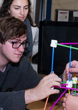 Two U N E students work on a project in the Makerspace