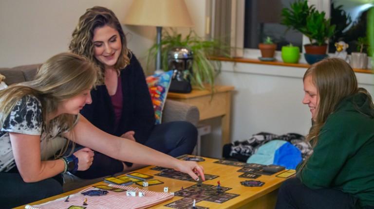 Students playing a board game in their dorm room