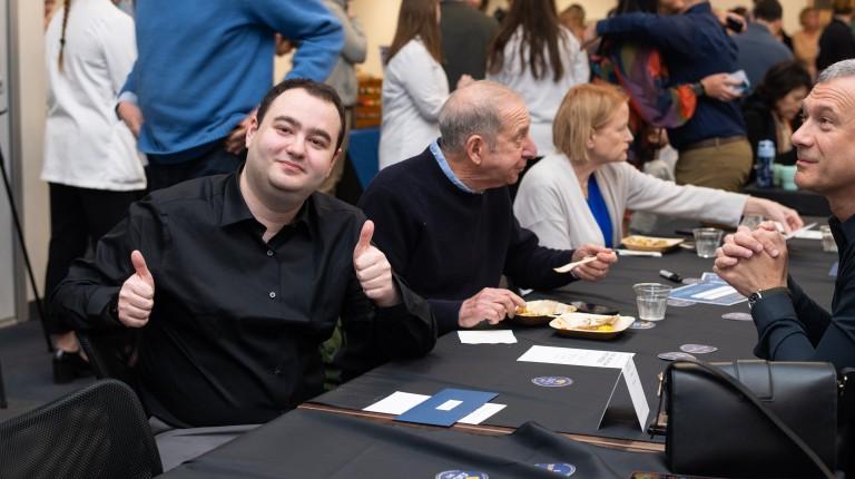 A male student gives two 'thumbs ups' while celebrating Match Day