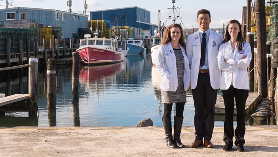 Three graduate students standing by the Widgery Wharf in Portland, Maine