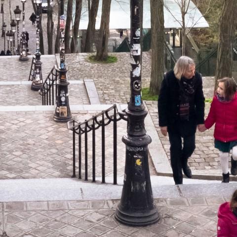 Photo of people walking up and down steps and sitting at cafe tables